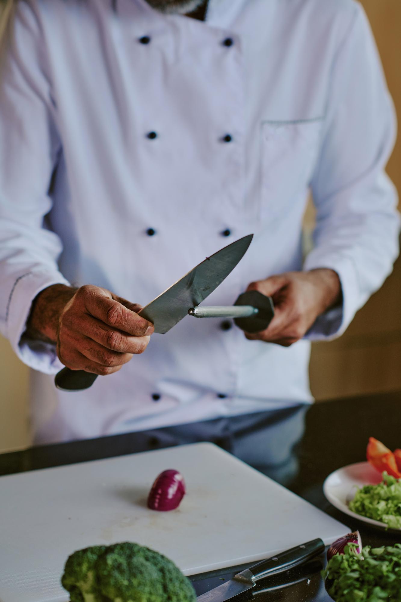 Chef che dimostra tecnica di taglio in cucina